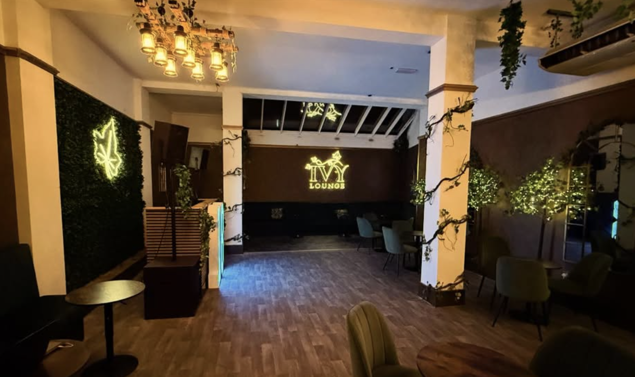 The Ivy Lounge bar area with a glowing gold IVY LOUNGE sign and hanging ivy