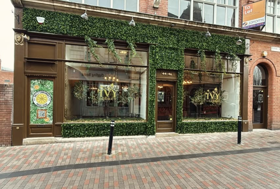 The ivy-covered exterior of Ivy Lounge with warm glowing windows